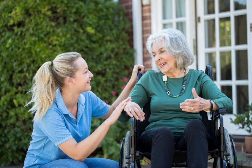 Young woman next to older woman using a wheelchair