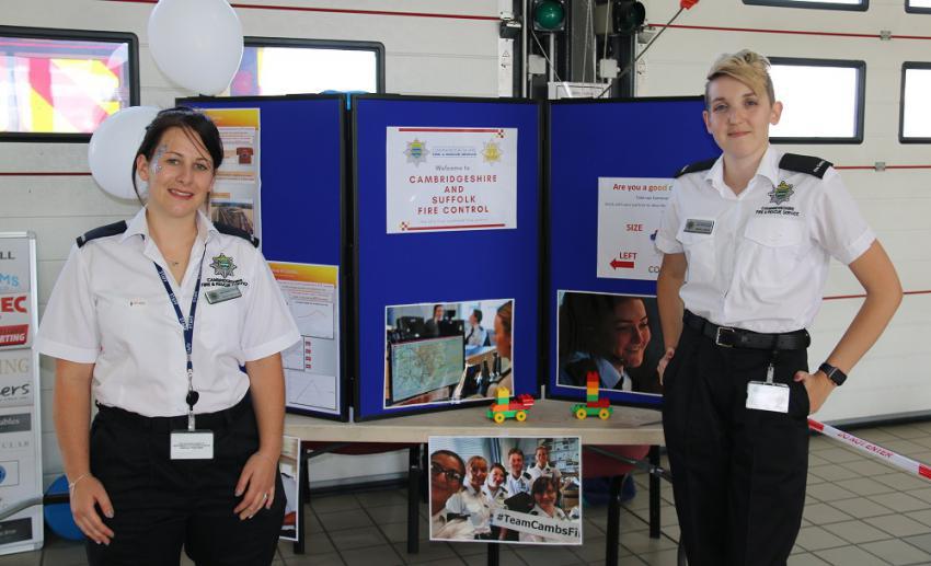 Two members of uniformed staff at a display stand during an open day