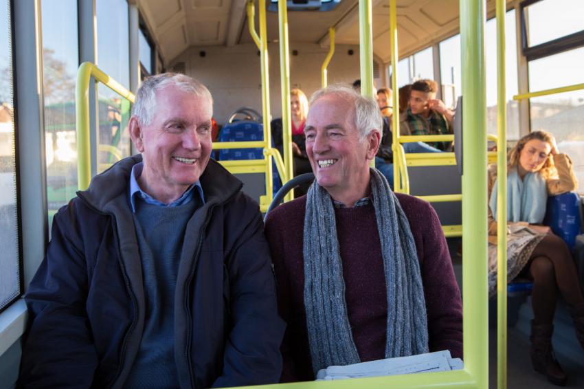 Two older men on a bus.