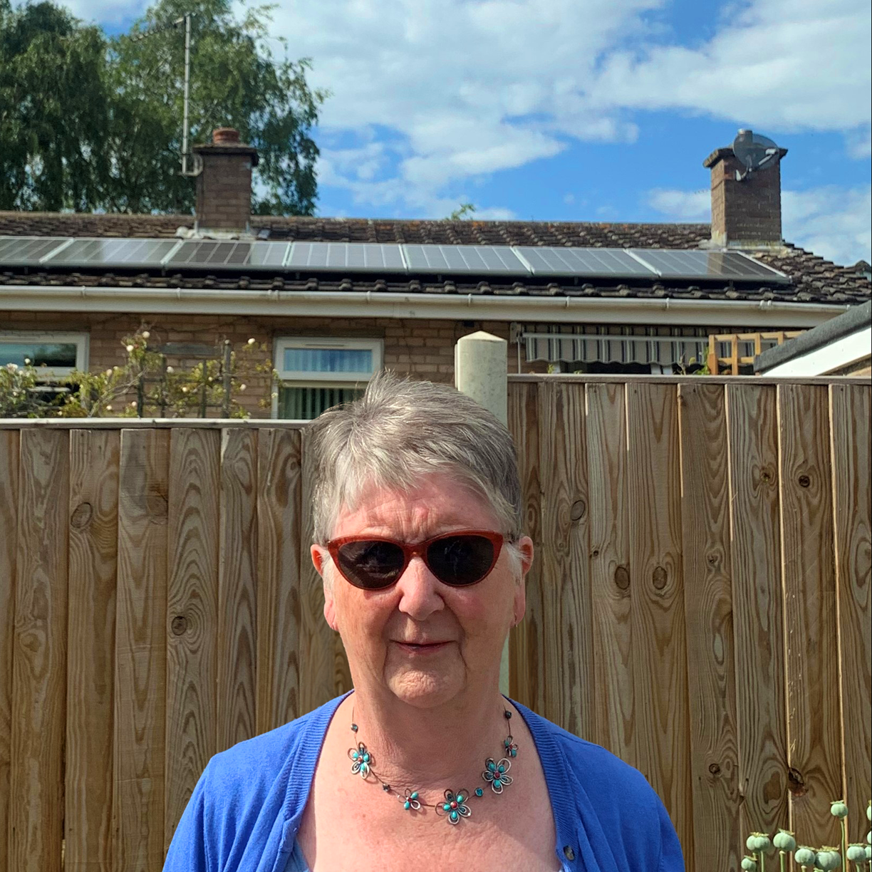 Jane stood in front of her house with new solar panels on the roof
