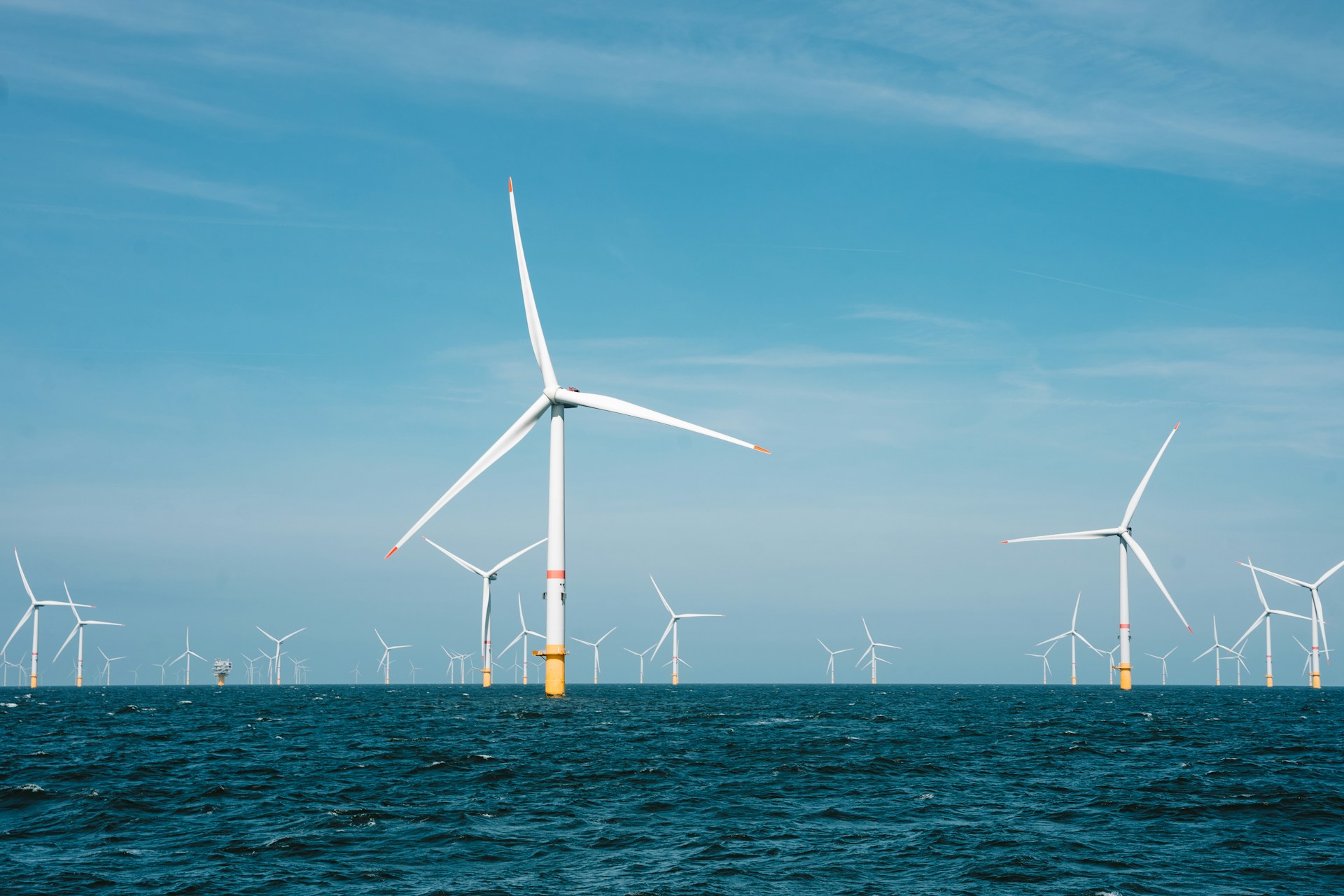 Off-shore Wind Farm in the sun, including lots of wind turbines.
