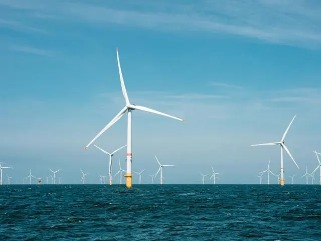 Off-shore Wind Farm in the sun, including lots of wind turbines.