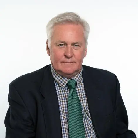 Cllr John Matthews wearing suit jacket, checked shirt and green tie