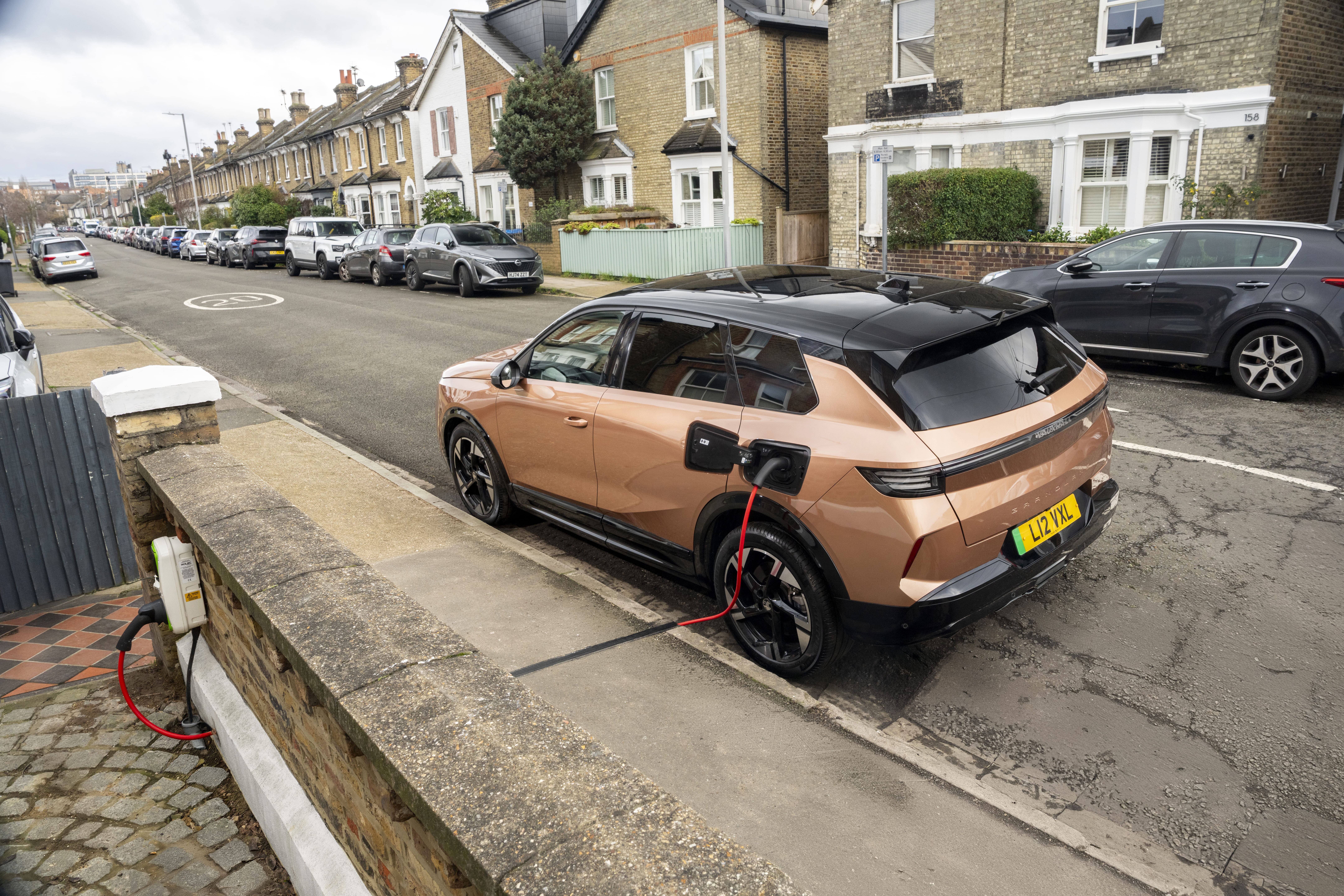 Electric or hybrid car being charged by a Kerbo-Charge point on a city street