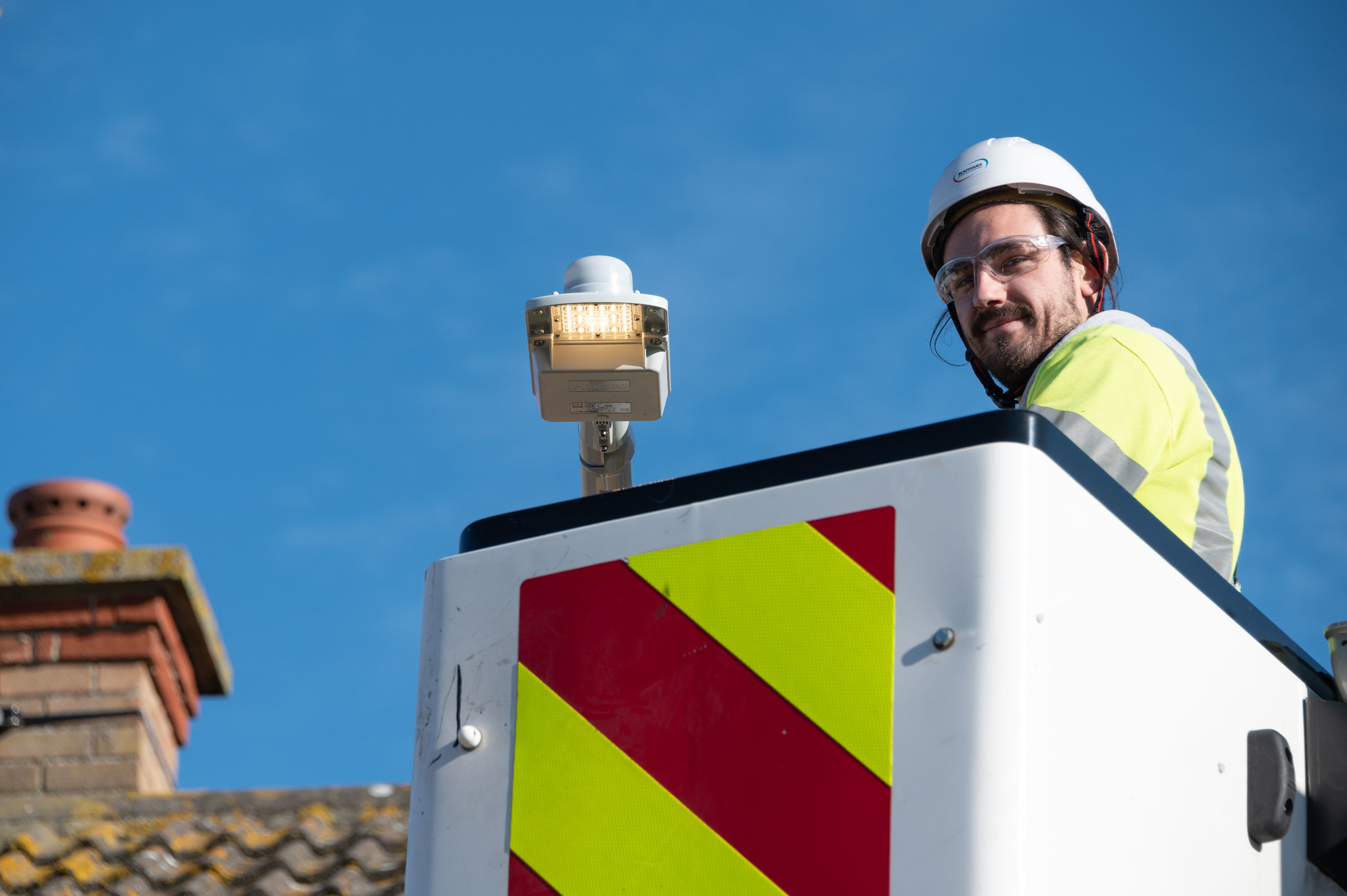 Man in high vis and hard hat on top of a crane