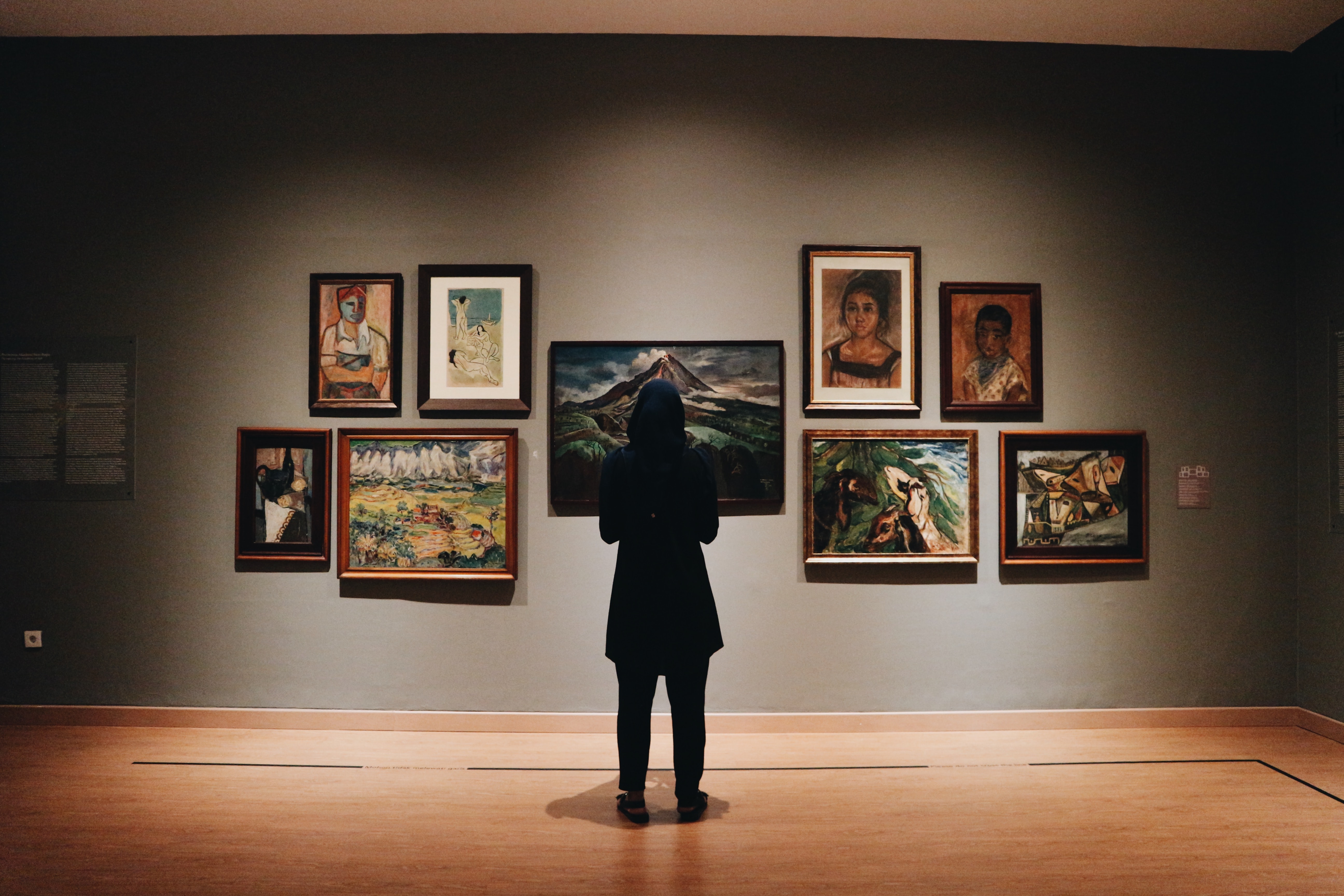 Person standing in front of artworks in an art gallery