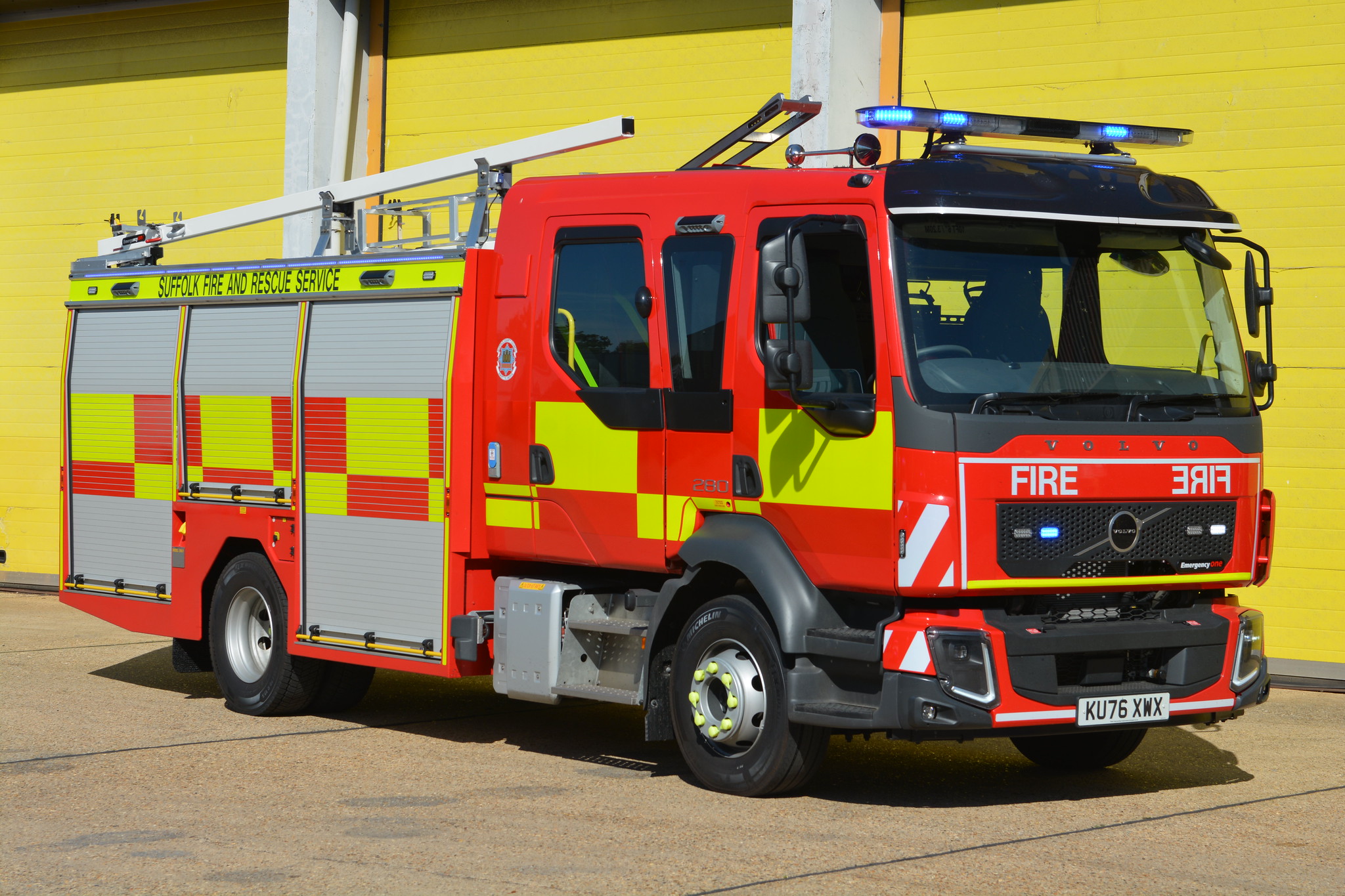 New fire engine in front of yellow shutters