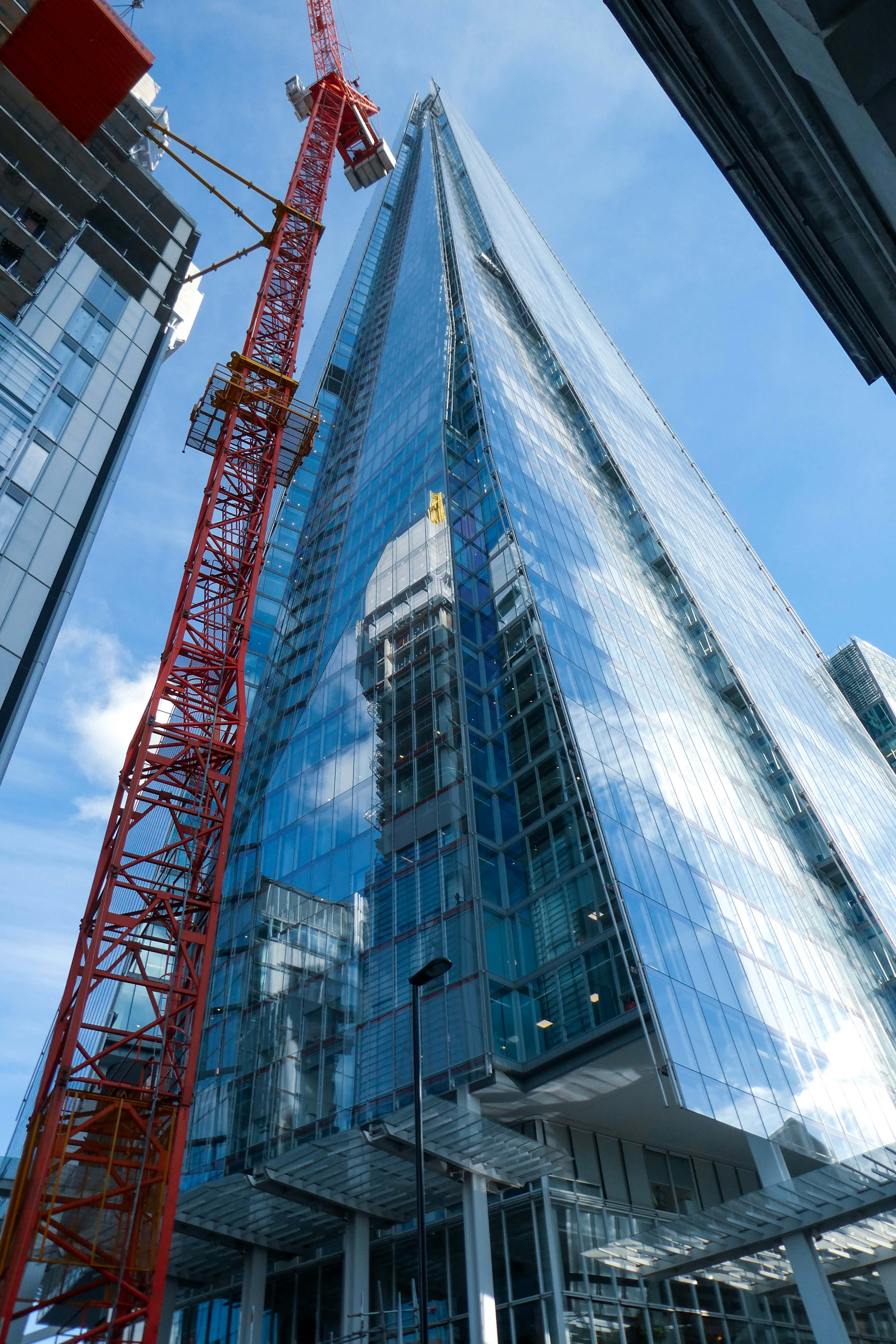 Photograph of construction happening on a skyscraper in a city