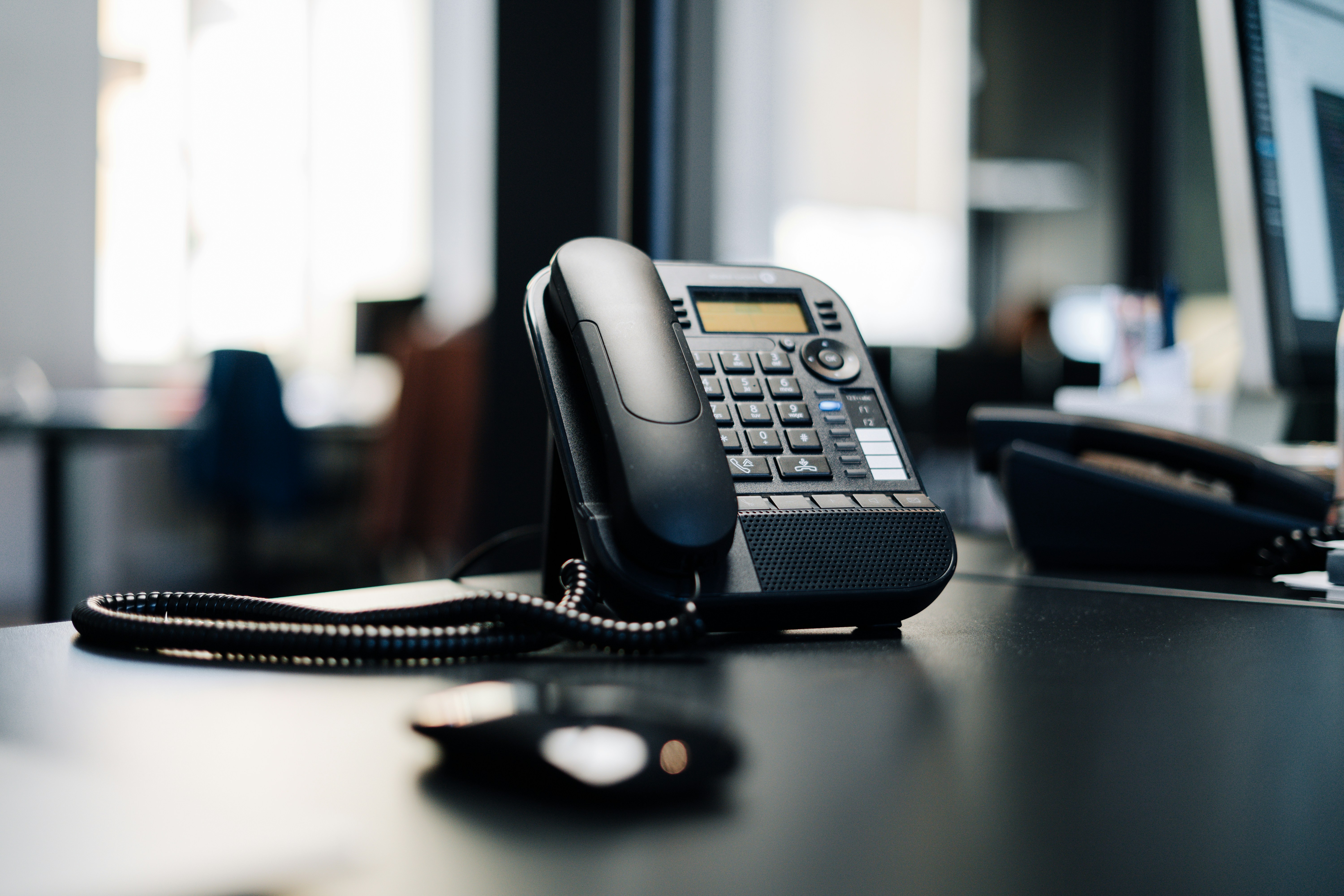 Black office phone on a desk