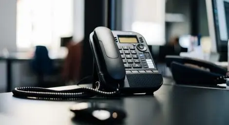 Black office phone on a desk