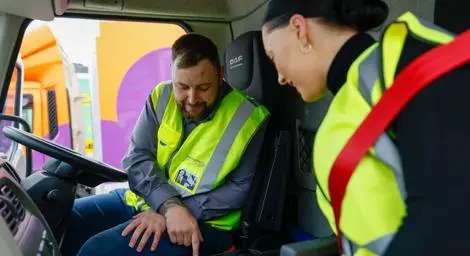 A trainer with a trainee in a lorry cab discussing controls