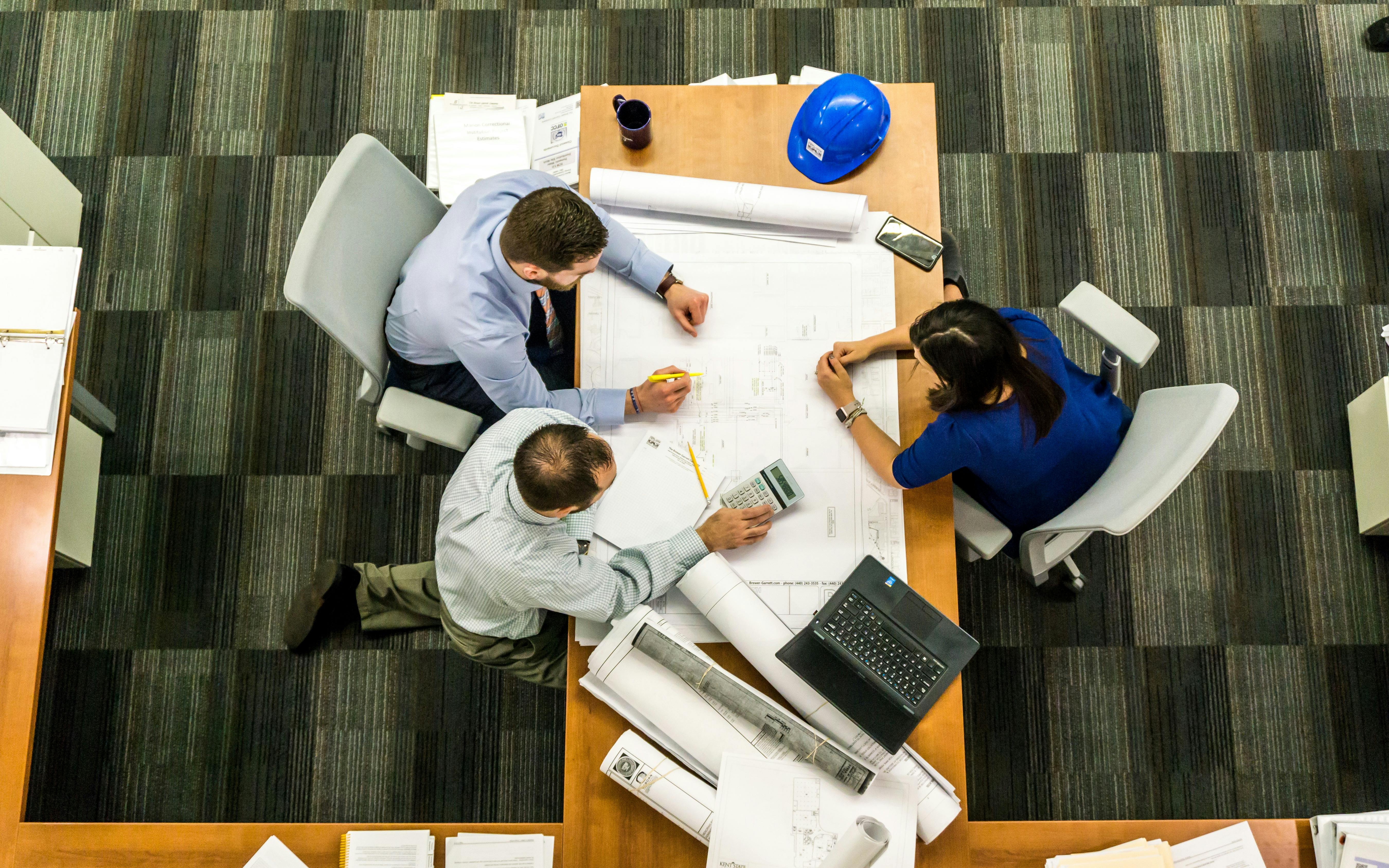 people reviewing building plans at a desk