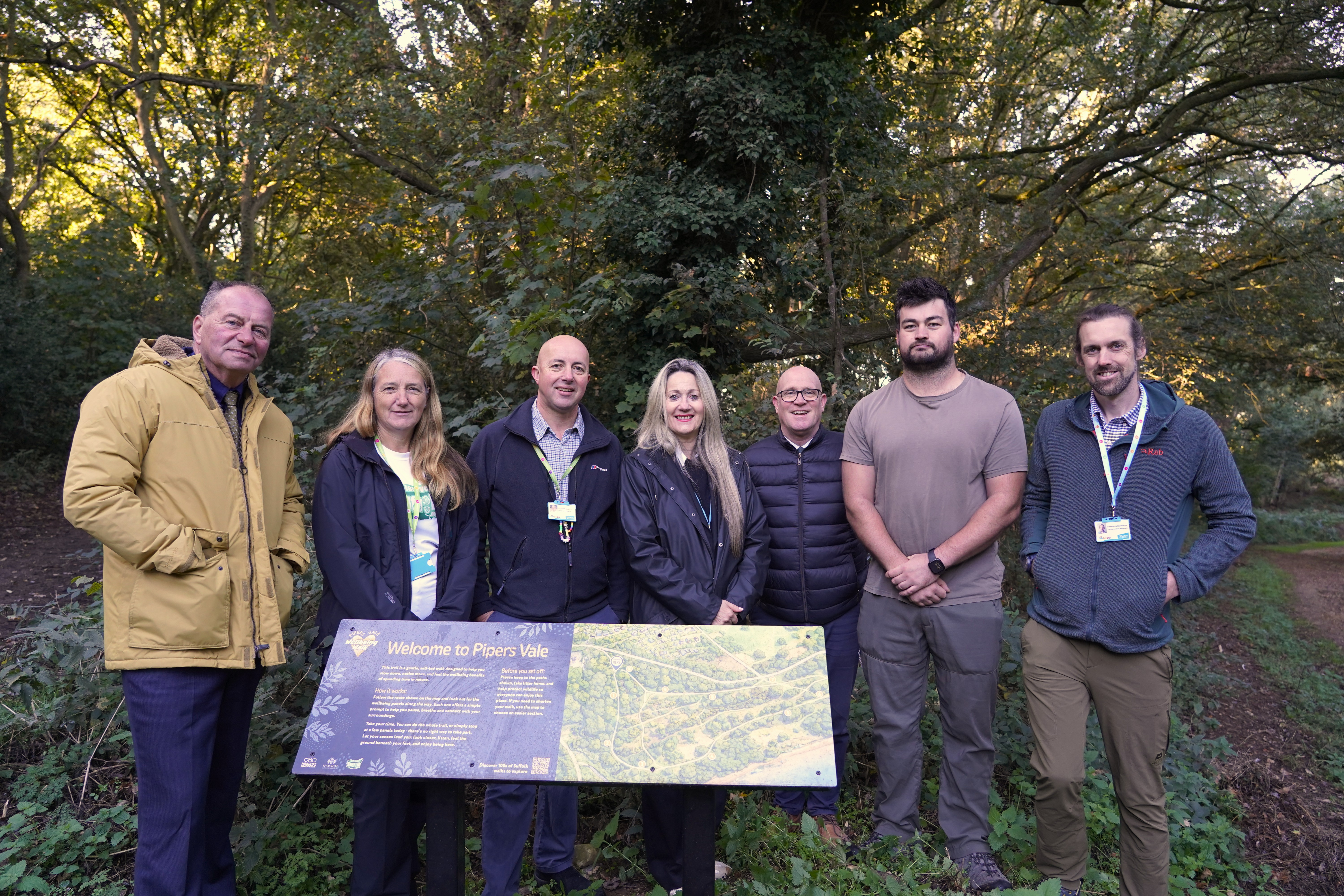 Councillors and officers standing at the entrance to the new Pipers Vale Wellbeing Trail at Orwell Country Park.