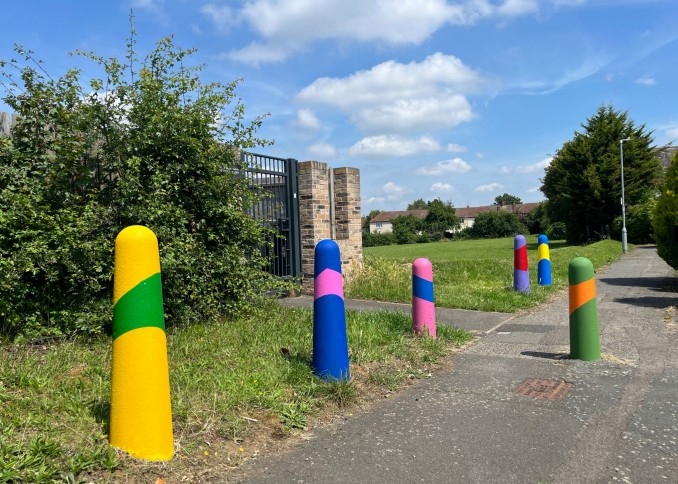 Multi-coloured posts on a pavement