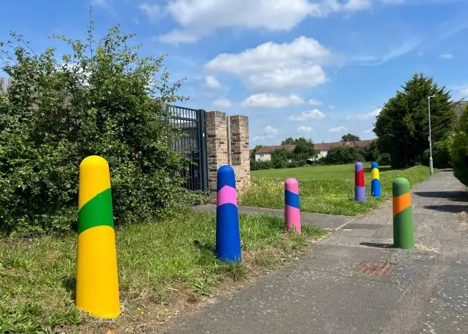 Multi-coloured posts on a pavement
