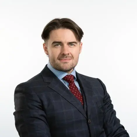 Councillor Tonkin-Galvin wearing a navy blue checked jacket with a blue and white striped shirt and red tie smiling