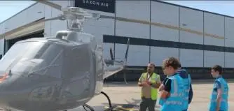 Three people standing around a helicopter