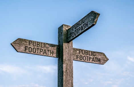 Sign post showing three directions with Public Footpath on each sign