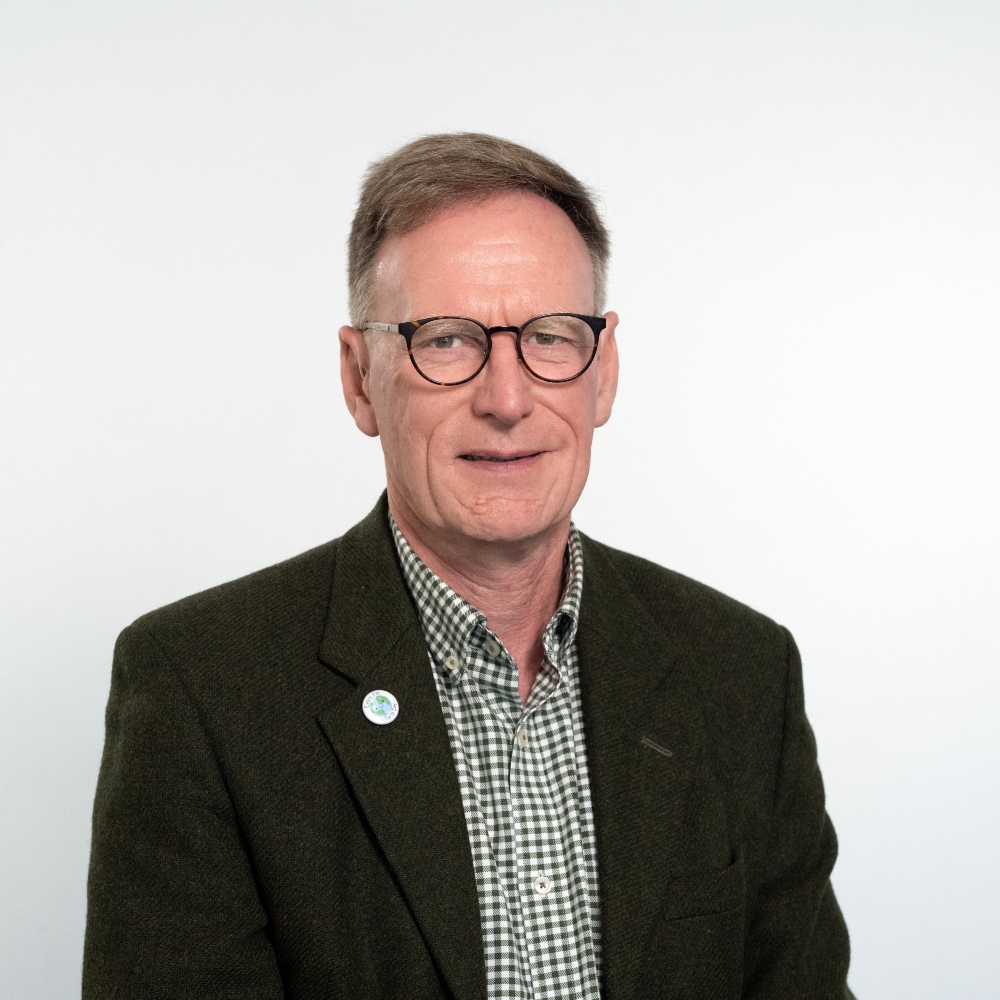 Councillor Simon Dowling wearing a dark green jacket and checked green and white shirt smiling