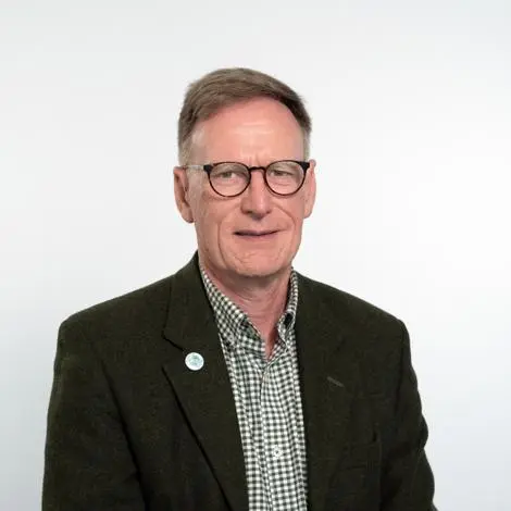 Councillor Simon Dowling wearing a dark green jacket and checked green and white shirt smiling