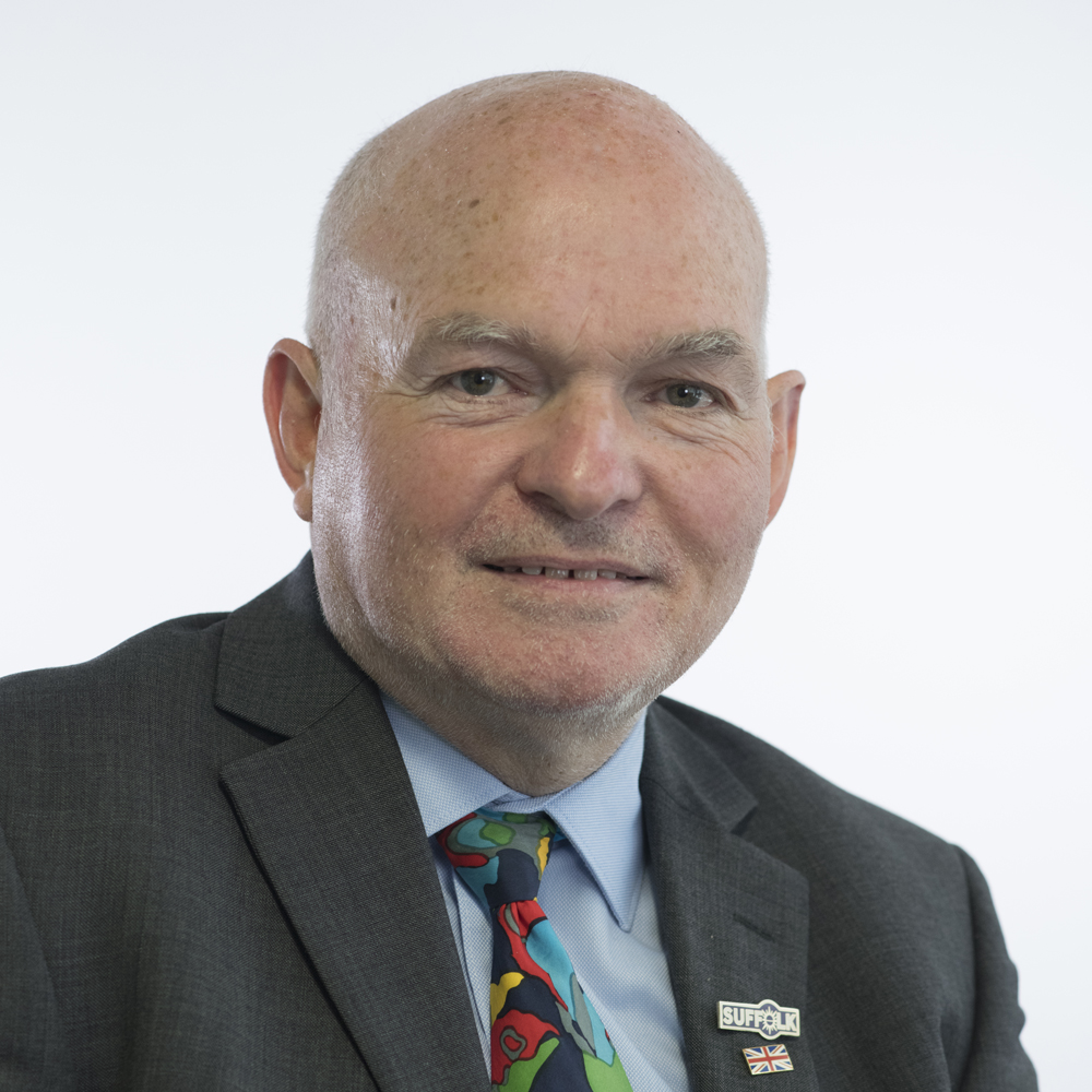 Image of Stephen Burroughes Councillor wearing suit jacket, blue shirt and multi coloured tie