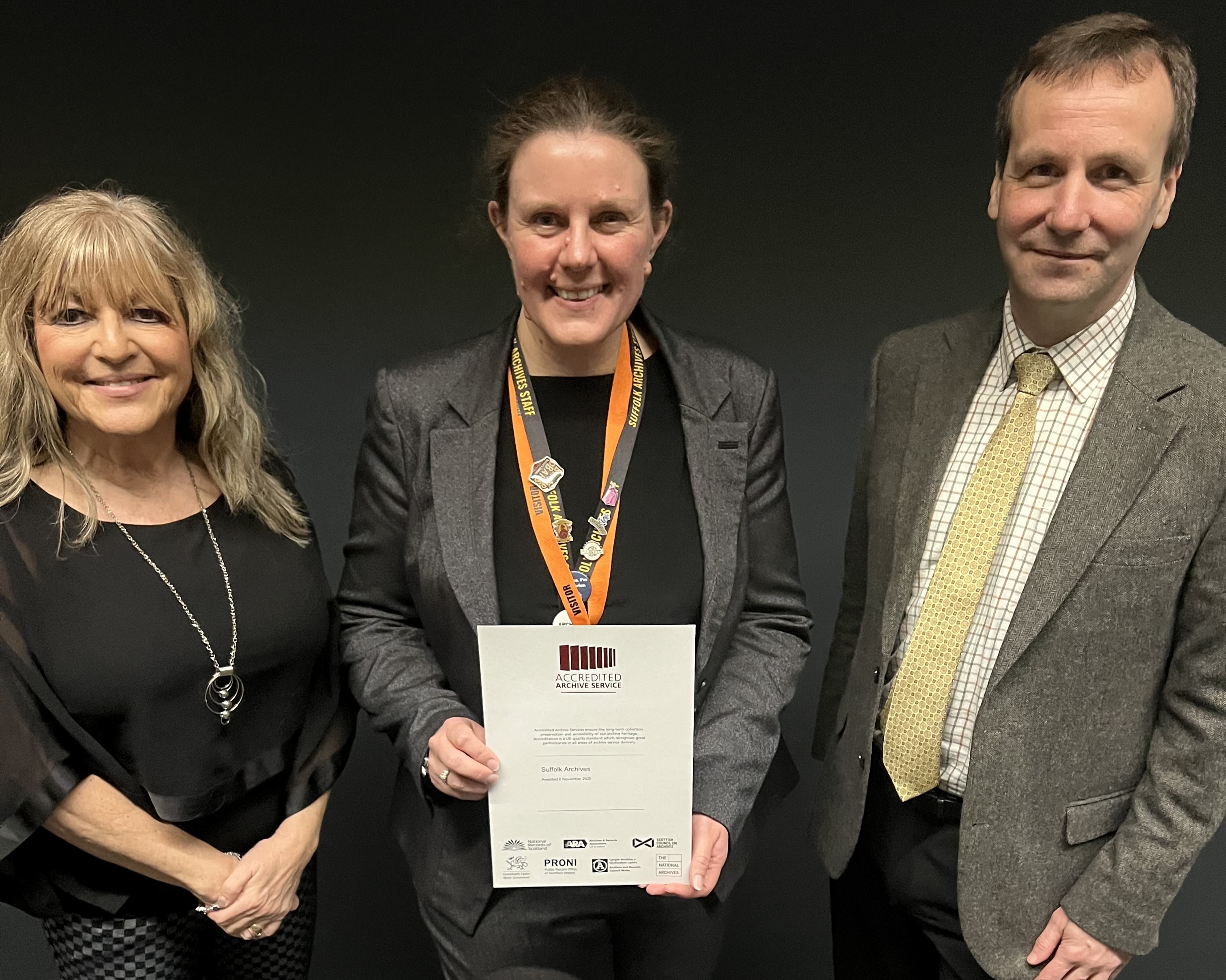Three people standing with the certificate 