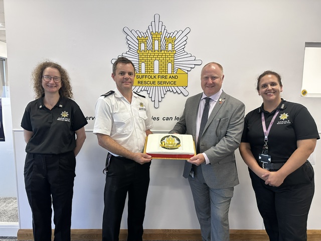 Jon Lacey, Chief Fire Officer and Cllr Tristan Gale, Cabinet Member present a 1-year birthday cake to the team