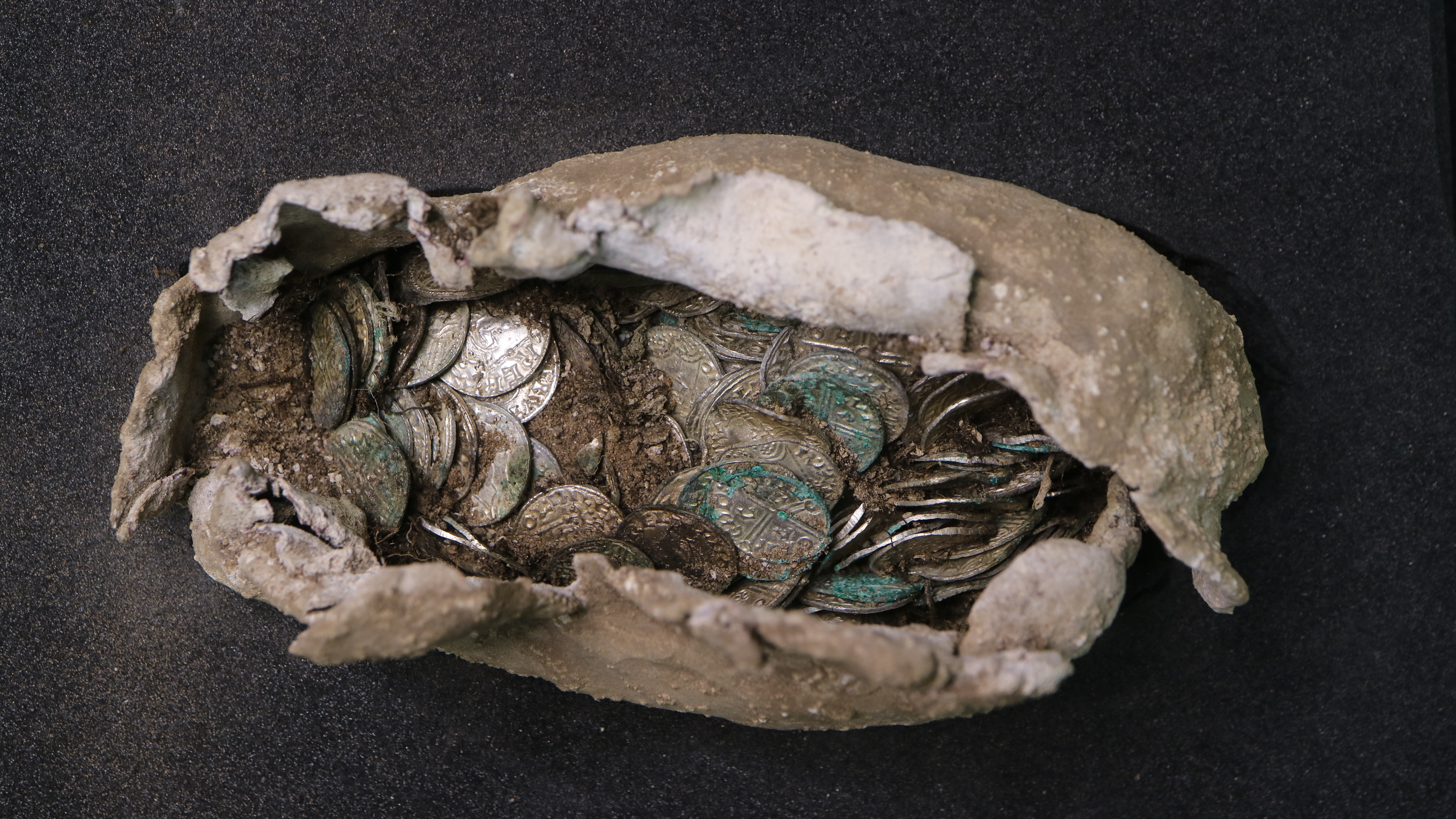 a cloth and lead sack slightly open to reveal silver coins inside
