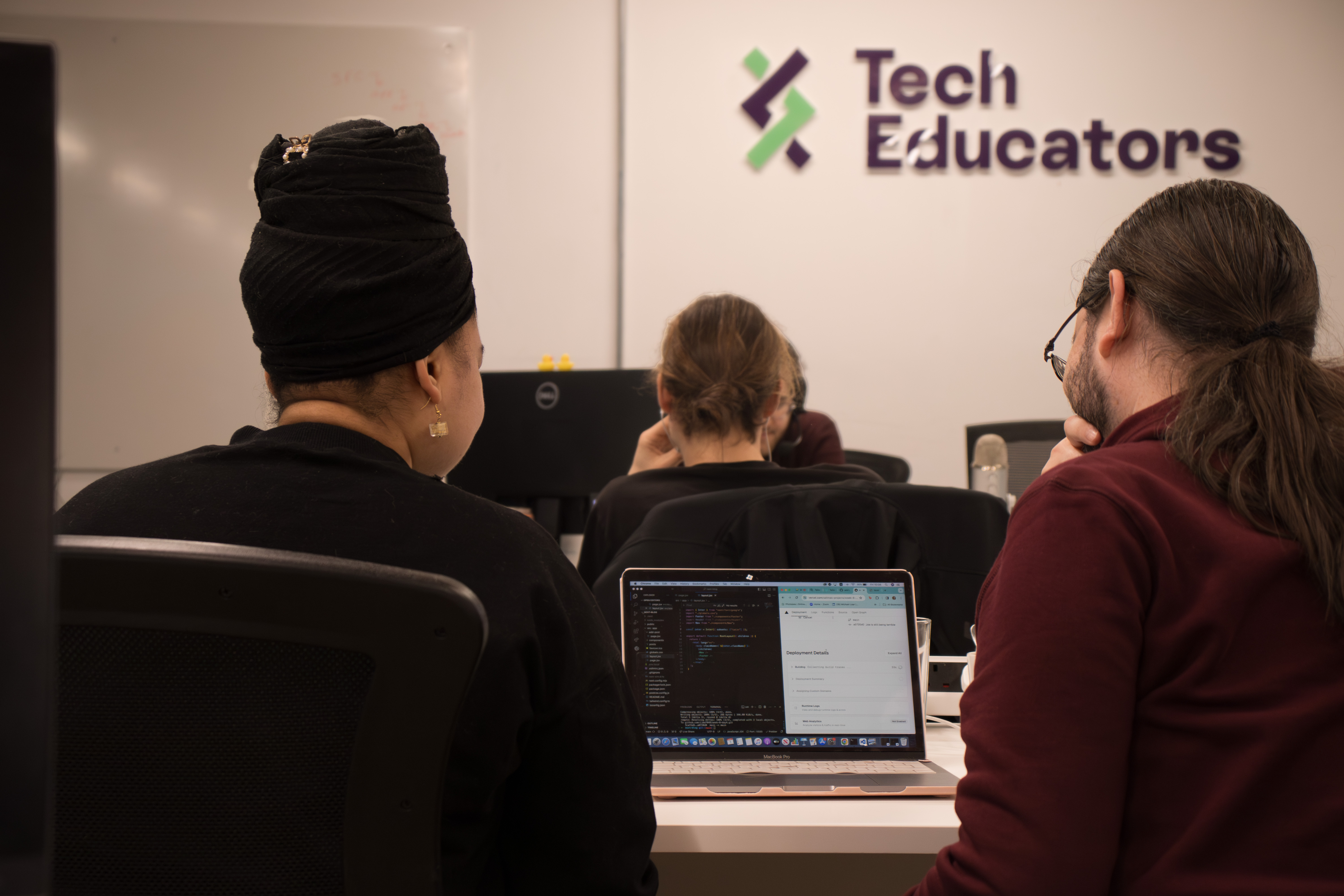 Two people sitting at a desk within Tech Educators offices