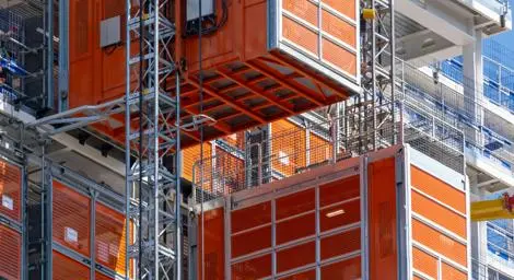 Cages attached to two cranes on a construction site