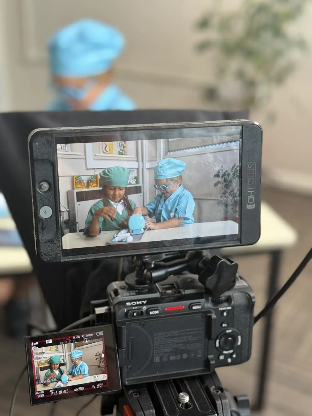 Two children dressed as dentists being filmed