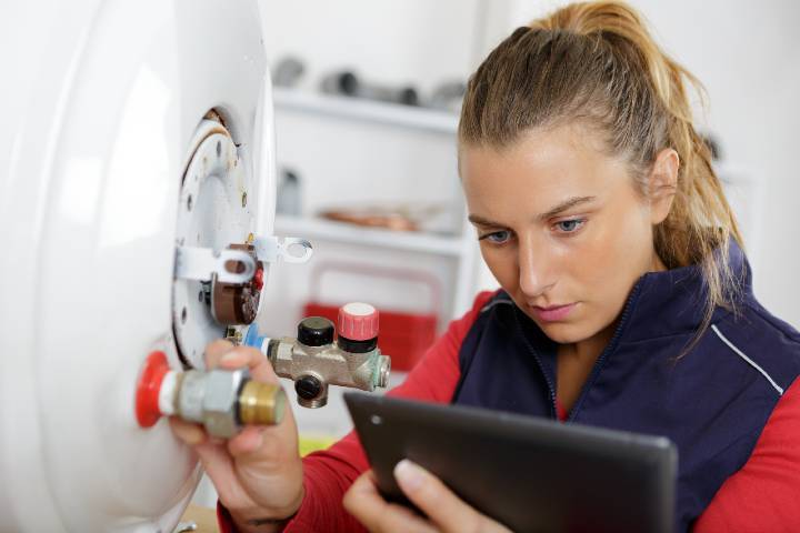 Trader looking at a mobile device while adjusting a valve