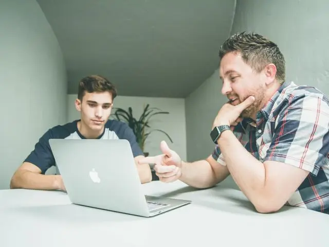 Two men looking at laptop