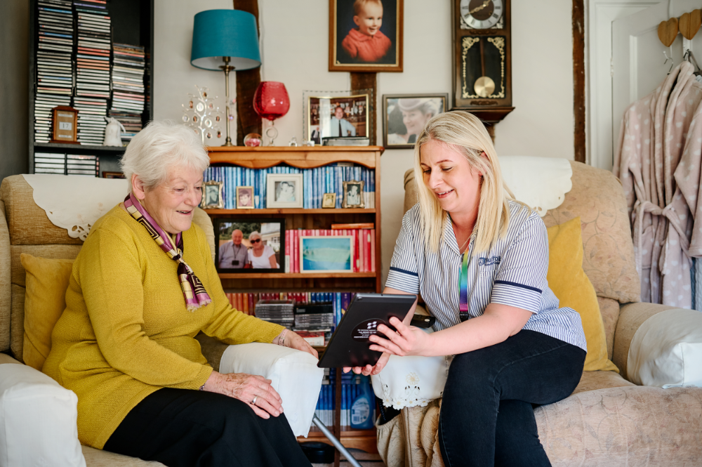 Two women sitting chatting in a living room. 