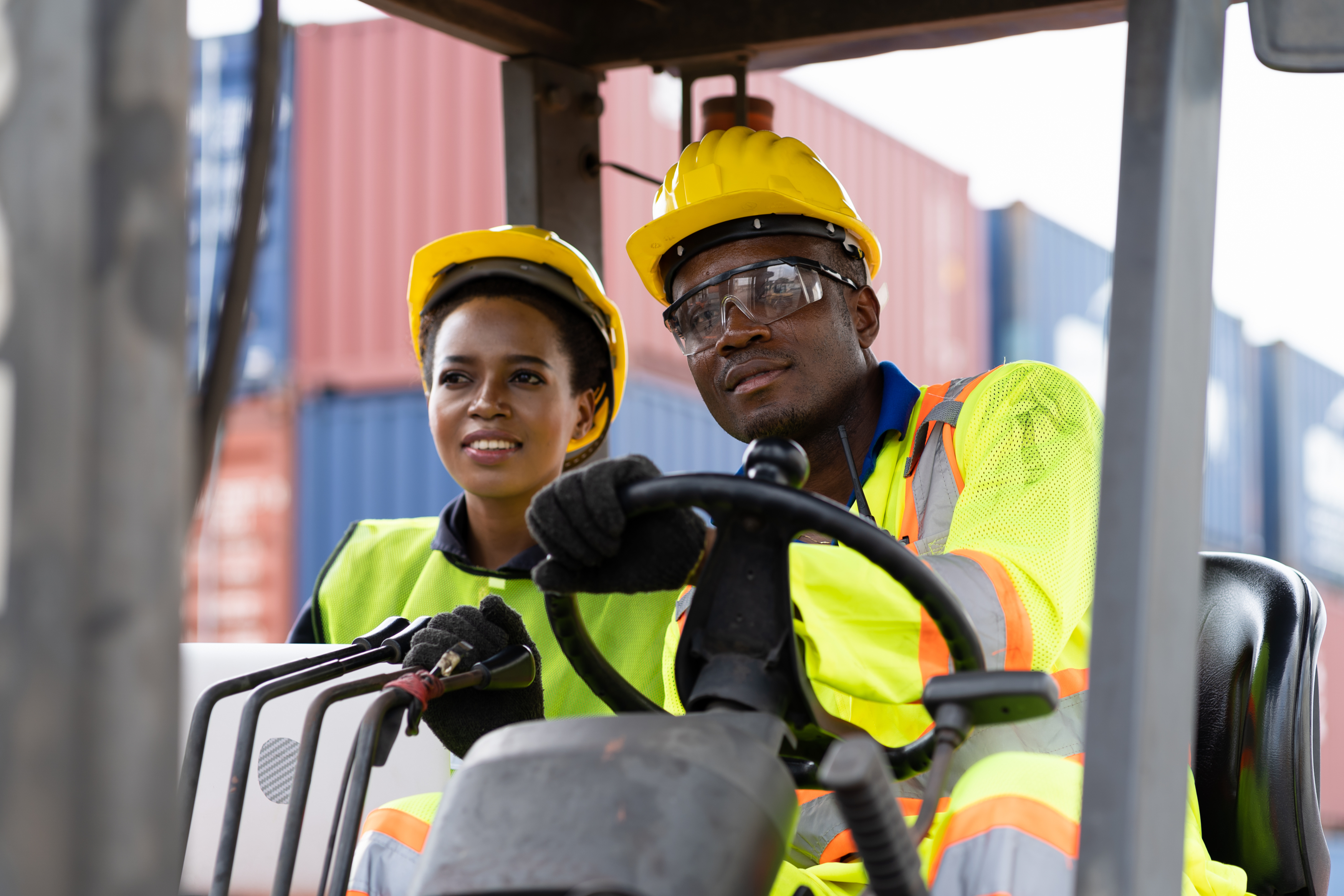 Man and women on a forklift truck at some docks