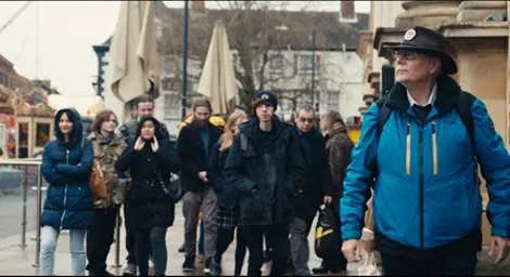 A tour guide is leading a group of people through a town centre