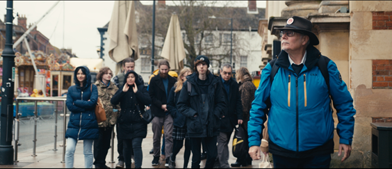 A tour guide is leading a group of people through a town centre