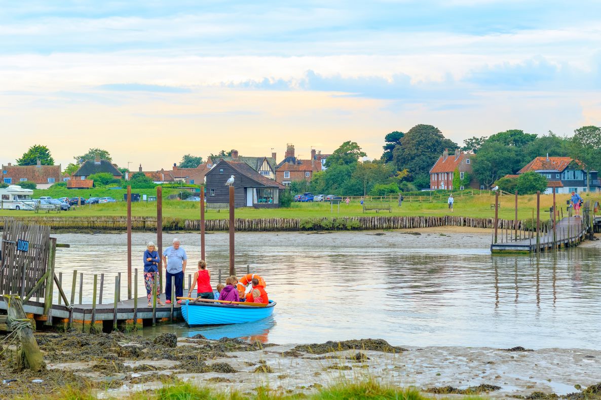 Family on a blue boat with Walberswick in the background