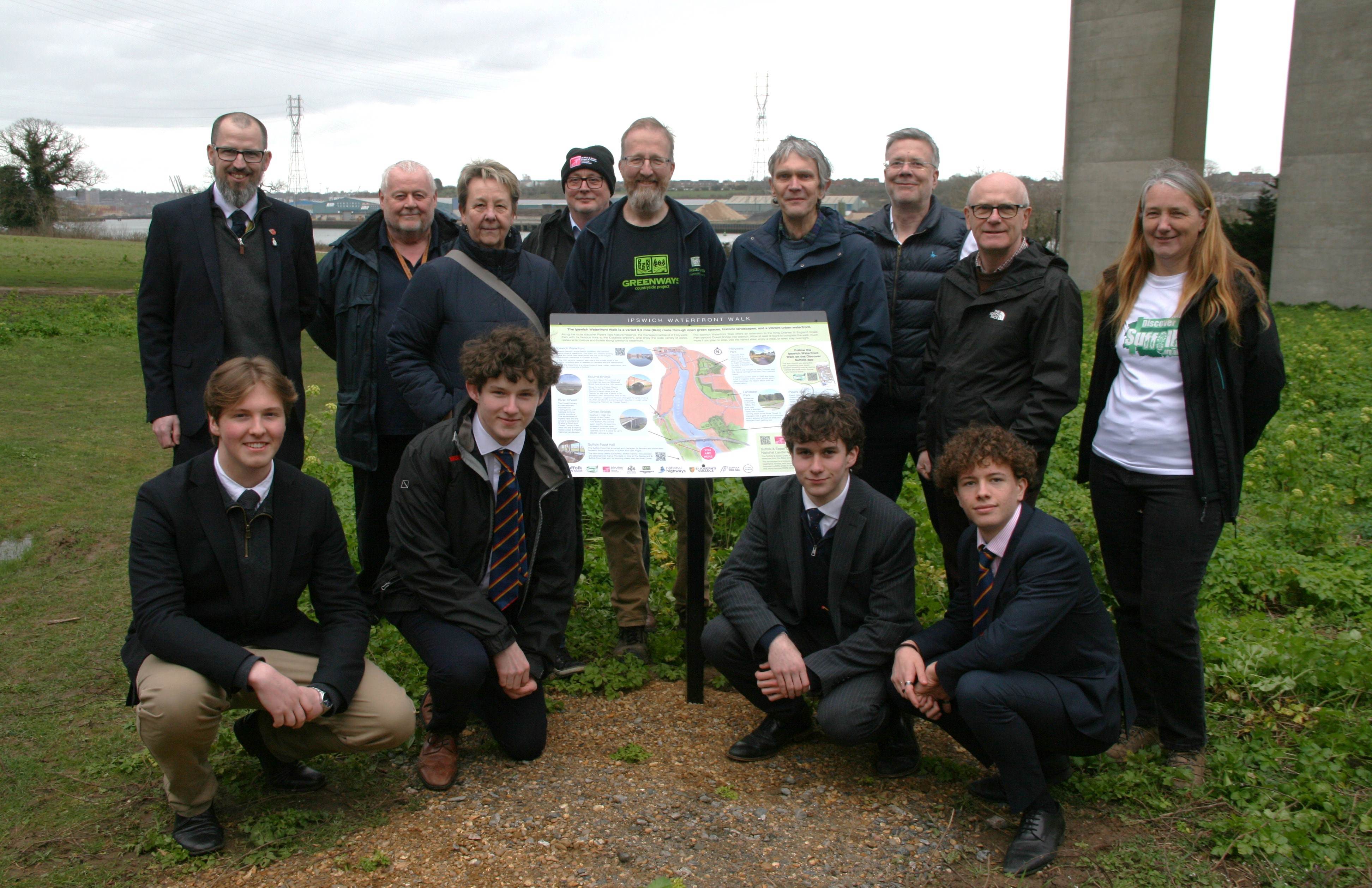 People standing next to an information board.