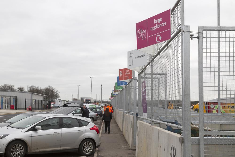 Photograph of a waste hub, people removing rubbish from cars and recycling their items in the correct waste disposal