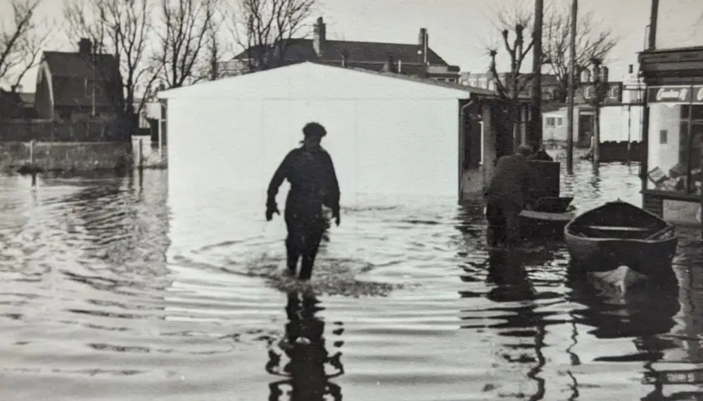 A photograph of the 1953 flood showing a person walking through the water