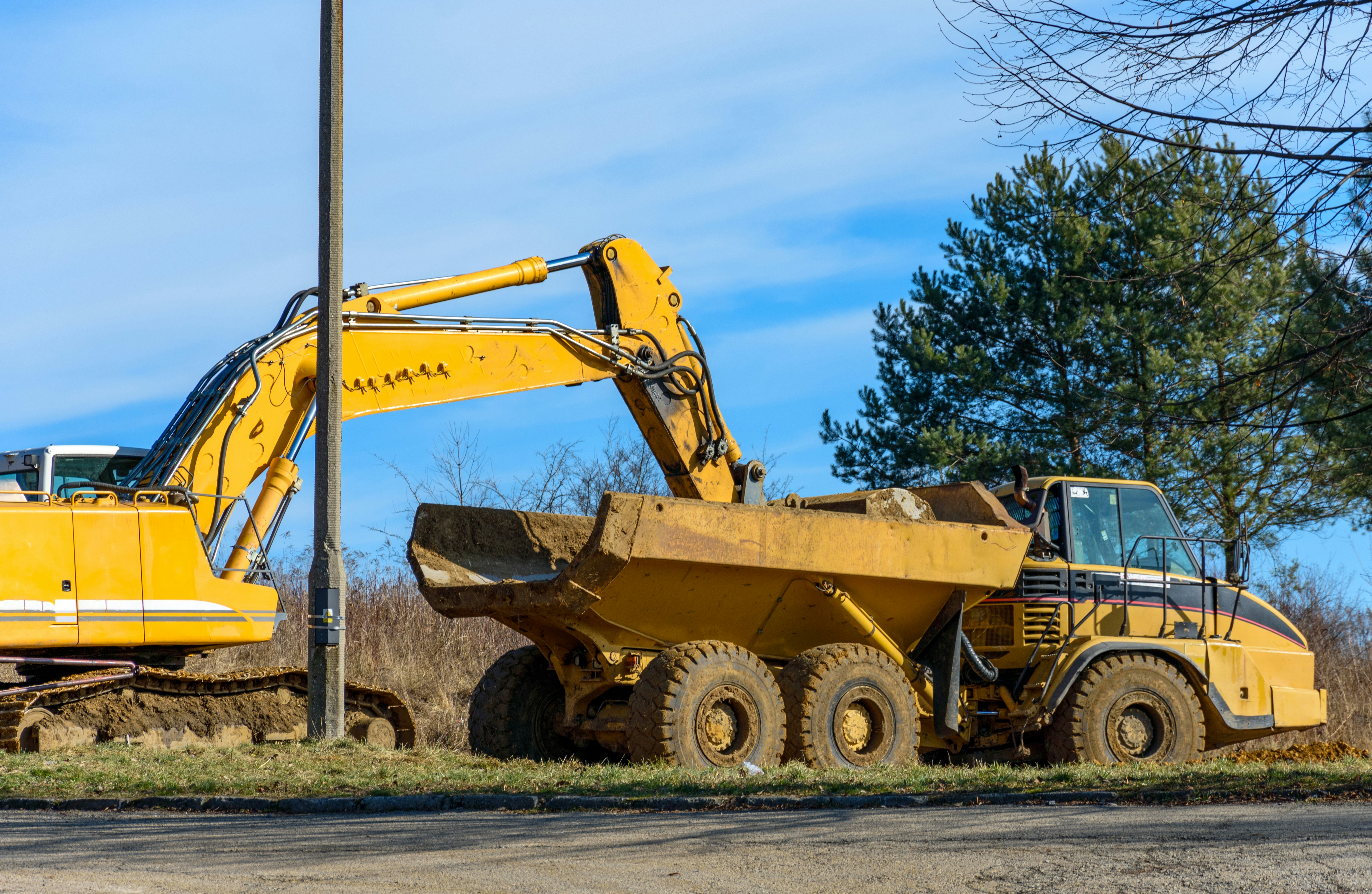 digger and dumper truck working alongside a road