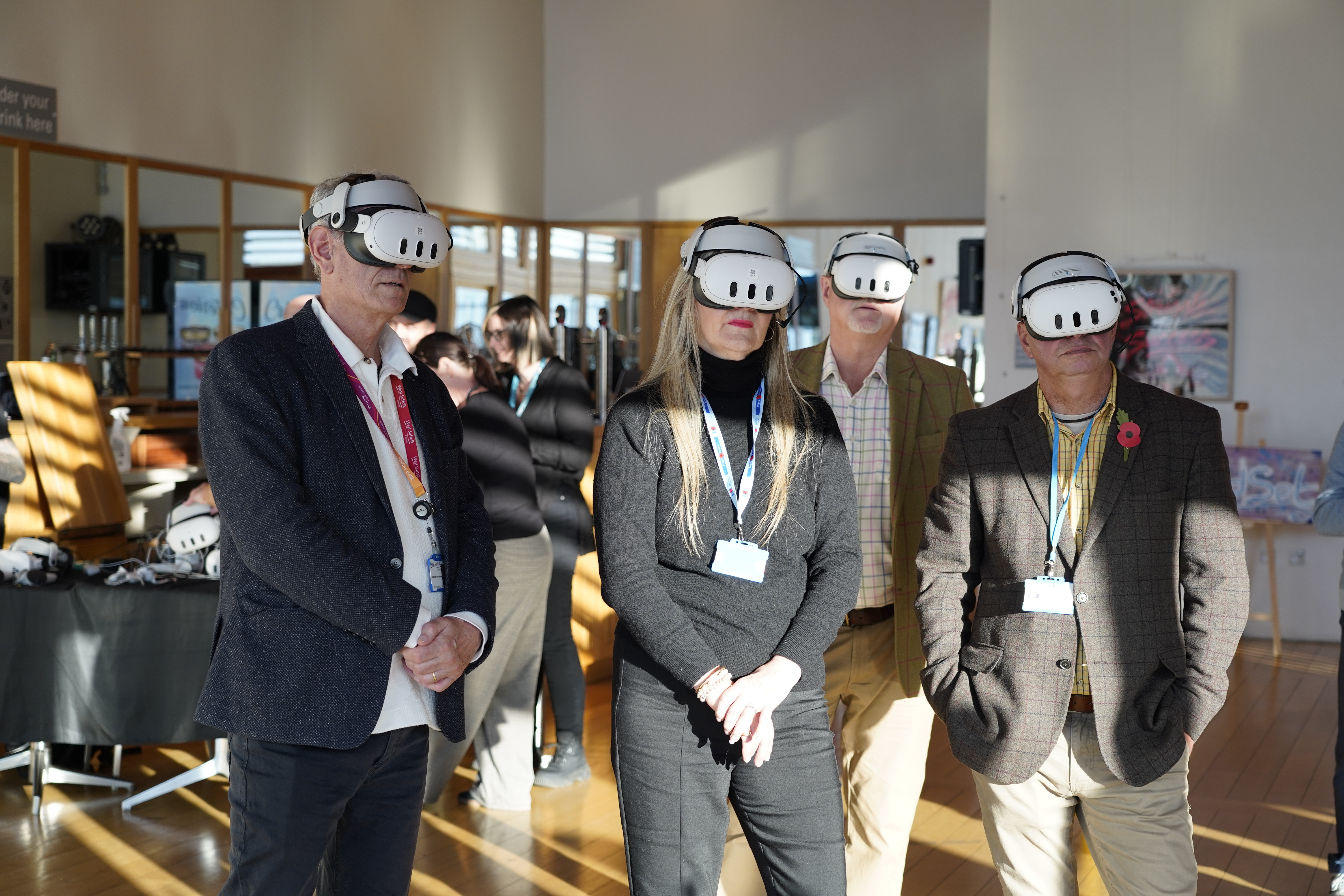 Four people wearing Mixed Reality headsets looking straight ahead.